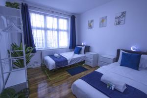 ein Schlafzimmer mit zwei Betten und einem Fenster in der Unterkunft Spacious 3-Bed Detached Home in London-Greenford in Northolt