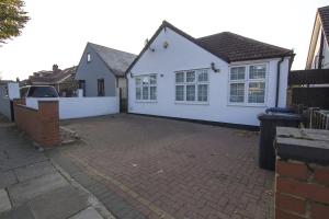 ein weißes Haus mit einem Zaun und einer steinernen Einfahrt in der Unterkunft Spacious 3-Bed Detached Home in London-Greenford in Northolt + 14 Fotos