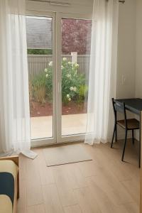 a bedroom with a sliding glass door with a desk at Grand Studio entier proche de Tours in Esvres
