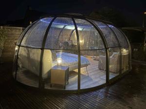 un cenador con una cama en su interior en Dôme du puits avec jacuzzi et sauna privatif, en Havinnes 2 fotos más