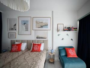 a bedroom with a bed with red pillows and a couch at Green Sea Studio in Rethymno