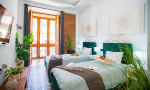 une chambre d'hôtel avec deux lits et un balcon dans l'établissement Luxury Views Plaza Constitución - Executive Malaga Center, à Malaga