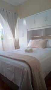 ein Schlafzimmer mit einem großen weißen Bett mit Handtüchern darauf in der Unterkunft Quarto ao lado da praça da Liberdade in Belo Horizonte