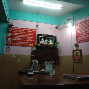 a restaurant with a table and a tv on a wall at V R S Dormitory in Hubli