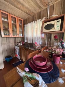 cocina con mesa y microondas en Pousada dos Sonhos - Casa Goiabeira, en Timbe do Sul