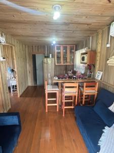 Una cocina y una sala de estar con mesa y sillas. en Pousada dos Sonhos - Casa Goiabeira, en Timbe do Sul
