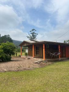 una pequeña casa en medio de un campo en Pousada dos Sonhos - Casa Goiabeira, en Timbe do Sul