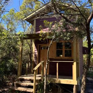 a tiny house with a porch and a deck at Punta Negra - Cabañas Cacarelhos in Piriápolis
