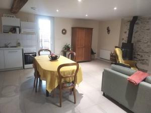 a kitchen and living room with a table and a couch at Logement proche du Lac & Océan, Parking in La Chevrolière