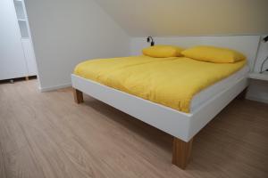 a bed with yellow sheets and pillows on it at Apartma Ana in Krško