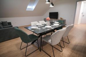 a dining room table and chairs in a living room at Apartma Ana in Krško