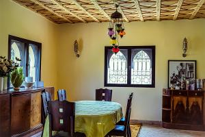 a dining room with a table and a window at Dar Lily, villa familiale avec piscine et services in Skoura +14 photos