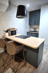 une cuisine avec un comptoir avec deux chaises et une table dans l'établissement Les Murs By le Clos, à Metz