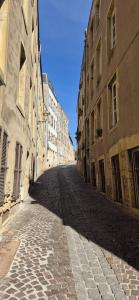 une rue vide dans une ville avec des bâtiments dans l'établissement Les Murs By le Clos, à Metz 1 autre photo