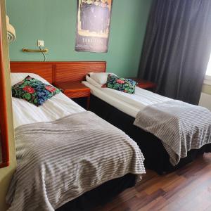 two beds in a hotel room withskirts at Highway Hotel in Härnösand