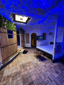 a bedroom with a bed and a blue ceiling at Appartement avec Sauna et Grand Spa in Béziers