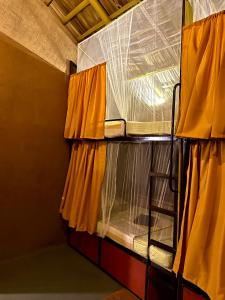 Etagenbett mit gelben Vorhängen in einem Zimmer in der Unterkunft Pepper Hills Hostel & Cottages in Ella