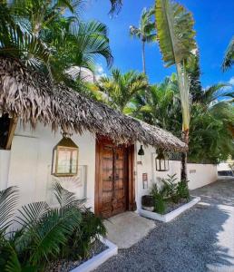 a house with a wooden door and some palm trees at Mahona Boutique Hotel in Las Terrenas