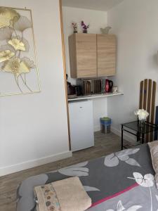 uma sala de estar com um sofá e uma cozinha em Petit studio attenant à la maison em Saint-Agnant