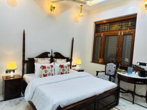 a bedroom with two beds and a desk and a window at Shanti vilas in Jaipur
