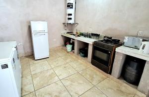 eine Küche mit einem weißen Kühlschrank und einem Herd in der Unterkunft Establo 2 - Casa Vacacional en Jujuy in San Salvador de Jujuy
