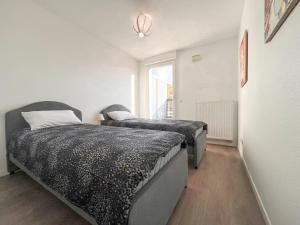 a bedroom with two beds and a window at Cenon plein ciel in Cenon