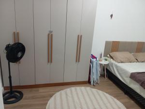 a bedroom with white cabinets and a white rug at Apartamento frente ao mar com piscina, a 5 minutos da Cachoeira 1 quarto in Mongaguá +13 photos