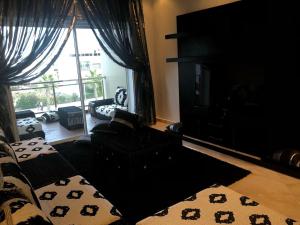 a living room with a couch and a large window at Apartment in residence CASABAY in Sidi Rahal