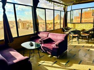 a living room with couches and a view of the pyramids at Energy Pyramids View in Cairo