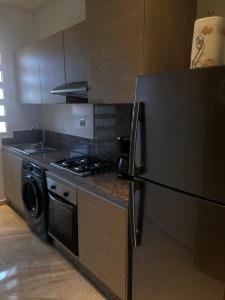 a kitchen with a refrigerator and a stove at Apartment in residence CASABAY in Sidi Rahal +4 photos