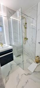 a white bathroom with a shower and a sink at Pensiunea Adriana Straja in Straja