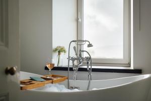 a bath tub with a glass of wine in it at Homely Cottage - Beaches, Costal walks, Castles in Newchapel +44 photos