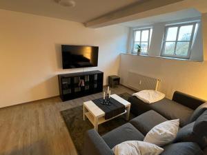 a living room with a couch and a tv at Ferienwohnung an der Kirchruine in Bautzen