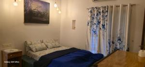 a bedroom with a bed and a table and curtains at sea zars villa in Cochin