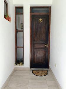eine Holztür in einem Zimmer mit Fliesenboden in der Unterkunft Casa Om ॐ in Cafayate