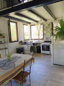 eine Küche mit einem Tisch und einem weißen Kühlschrank in der Unterkunft Casa Om ॐ in Cafayate
