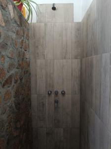 ein Bad mit einer Dusche und einer Steinmauer in der Unterkunft Casa Om ॐ in Cafayate