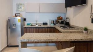 a kitchen with a counter top and a refrigerator at Cozy apartment just two blocks from the beach in Isla Venados