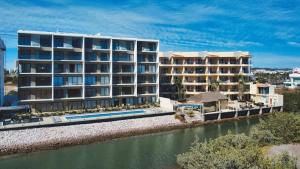 ein großes Apartmenthaus neben einem Wasserkörper in der Unterkunft Marina view pool and restaurants nearby in San Rafael