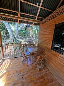 een houten veranda met een tafel en stoelen erop bij hotel san rafael in Santa Marta