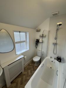 a bathroom with a tub and a toilet and a sink at Kingsmead Square Apartments in Bath