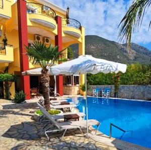 a hotel with a pool and chairs and an umbrella at Golden Star in Nydri
