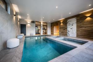 a swimming pool in a room with a large at ULTIMATE Les Gets Luxury - Above the Clouds with Sauna, Pool etc - Mansion Ensolielle for 15 in Les Gets