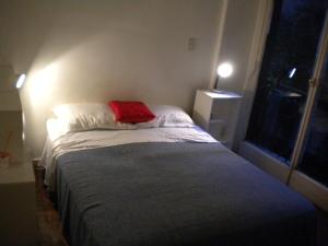 1 dormitorio pequeño con 1 cama con manta roja en Recoleta Apartamento en Buenos Aires