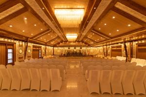 ein leerer Saal mit weißen Stühlen und einer Bühne in der Unterkunft Elbrus Resort & Spa in Theog