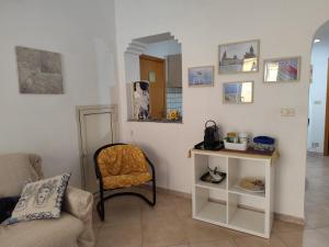 een woonkamer met een stoel en een tafel bij La Casa Di Via Marzulli in Acireale