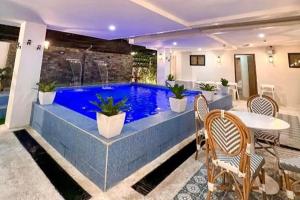 una piscina in una casa con tavolo e sedie di Aurora Suites Pasay near Airport a Manila