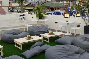 un patio con pouf, tavoli e sedie di Aurora Suites Pasay near Airport a Manila