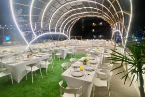 una stanza con tavoli e sedie bianchi e un soffitto di Aurora Suites Pasay near Airport a Manila Altre 43 foto