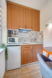 - une cuisine avec des placards en bois et un lave-vaisselle blanc dans l'établissement Forestside Stay at Stream Resort, à Pamporovo